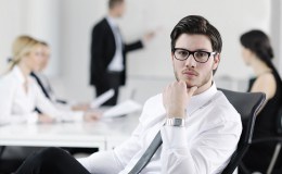 handsome young business man with colleagues in background